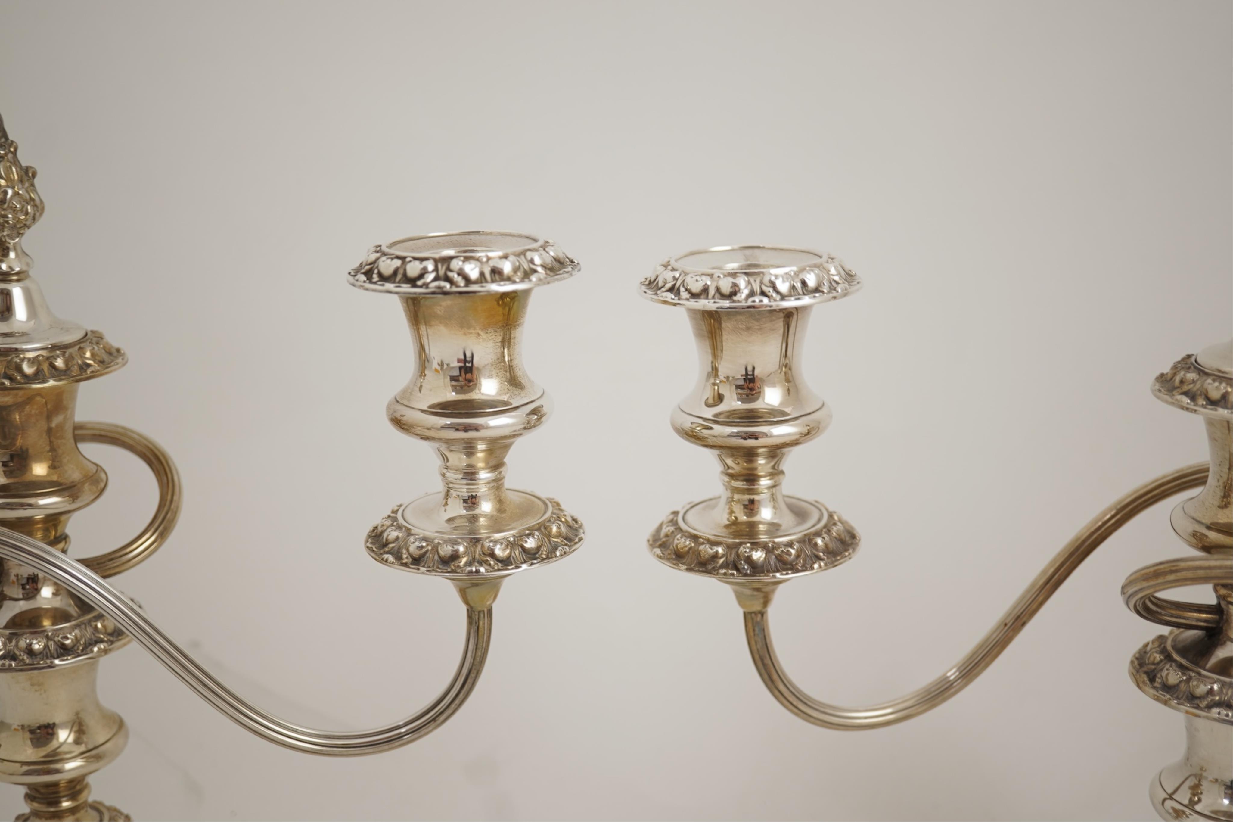 A pair of Elizabeth II silver dwarf two branch, three light candelabra by Barker Brothers Silver Co